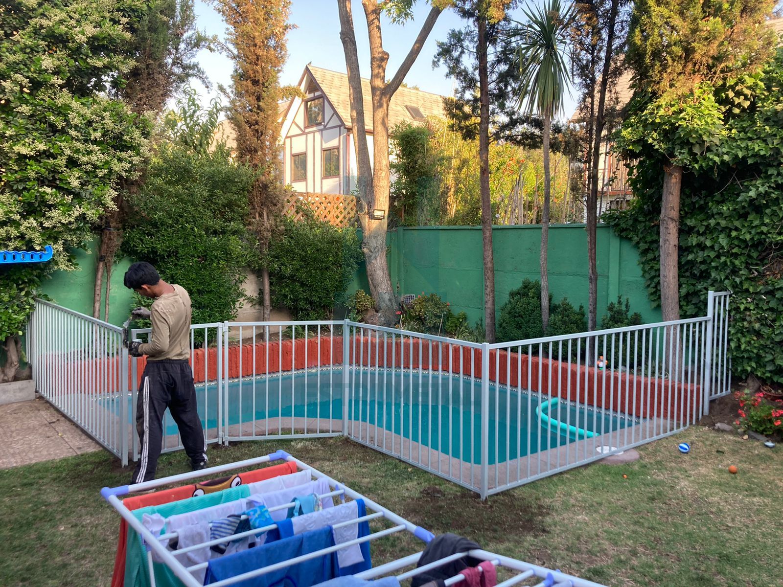 Reja tradicional para piscina mas económica del mercado, son barras verticales y horizontales por ambos lados de metal, protege a niños y mascota. Se instalo al borde de una piscina.
