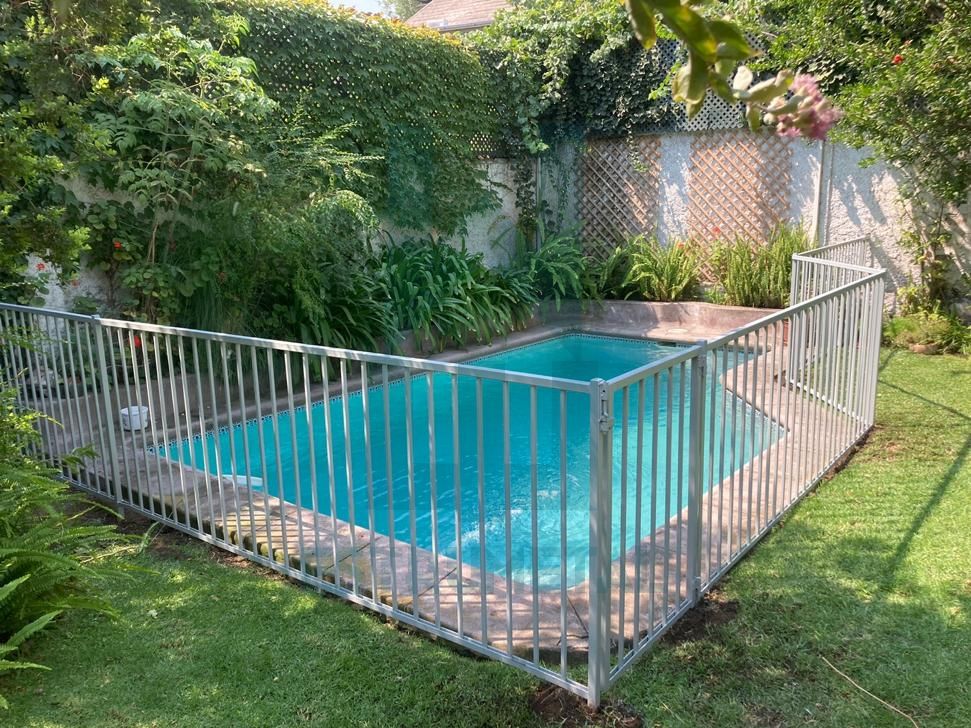 Reja tradicional para piscina mas económica del mercado, son barras verticales y horizontales por ambos lados de metal, protege a niños y mascota. Se instalo al borde de una piscina.